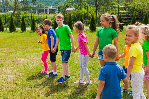 Children are holding hands and guessing riddles. Outdoor summer activities