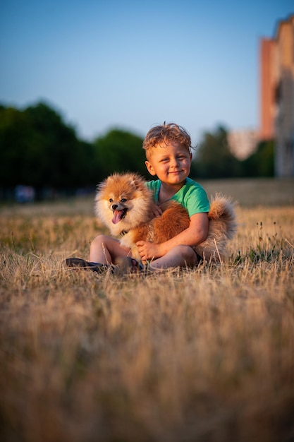 Foto i bambini stanno giocando con il cane nello spitz del prato per il testo