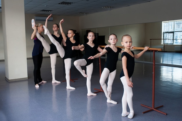 Foto ai bambini vengono insegnate le posizioni di balletto in coreografia