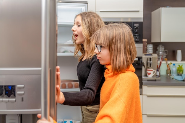 Photo the children are watching the fridge in the kitchen