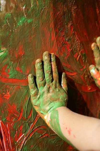 Mani dell'artista dei bambini che dipingono i multi colori