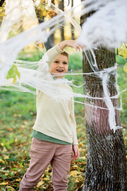 Bambini in autunno parco, una ragnatela sull'albero.