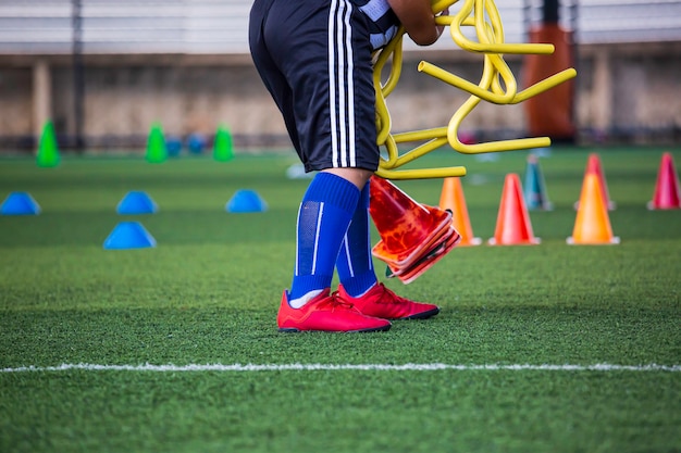 Фото Детский мяч собирает тактику на травяном поле с барьером для тренировки навыков в академии футбола