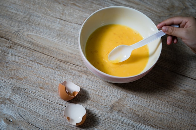 Children beat eggs on the table.