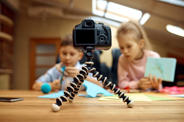 Children bloggers poses on camera, little bloggers. Kids blogging in home studio, social media for young audience, online internet broadcast