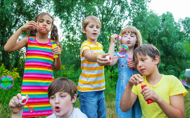 Children blow bubbles in the street. Selective focus.