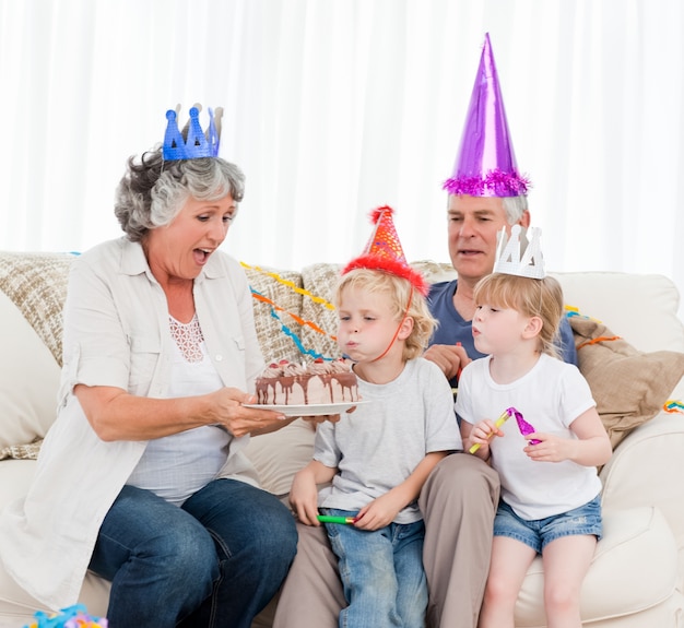 Children blowing on the birthday cake 