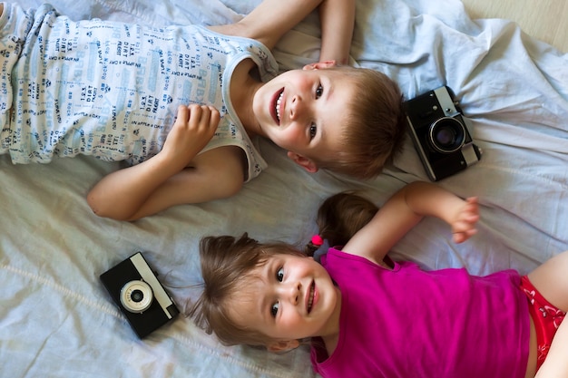 Children boy and girl brother and sister playing with cameras. 