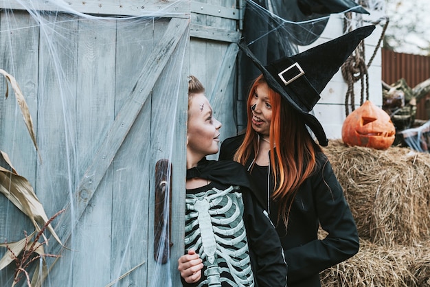 children a boy in a skeleton costume and a girl in a witch costume having fun at a halloween party