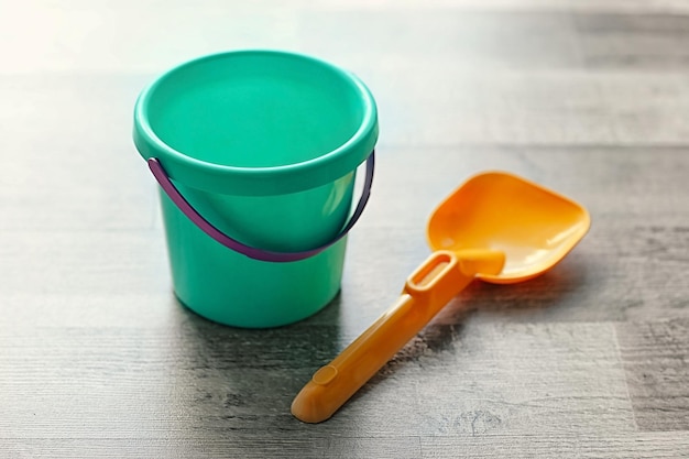 Children bucket and shovel on wooden floor