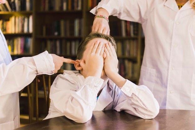 Photo children bullying little boy in library