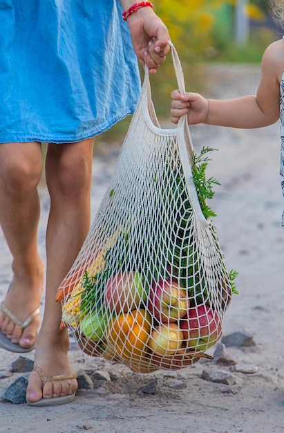 I bambini portano le verdure in una borsa messa a fuoco selettiva