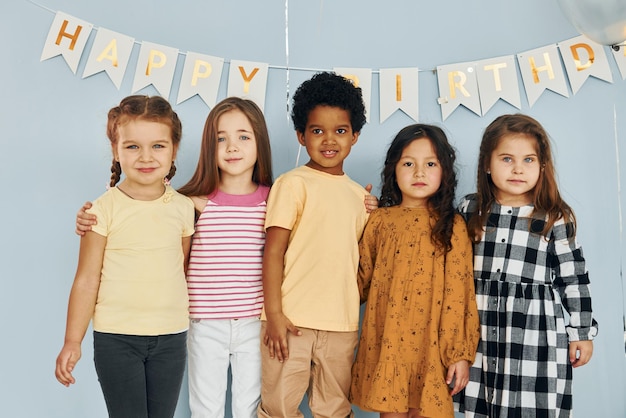 Children on celebrating birthday party indoors have fun together