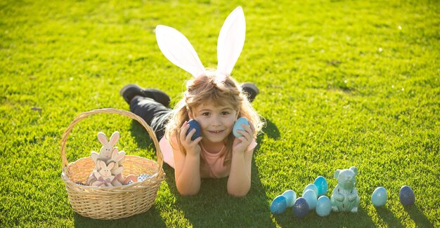 Bambini che celebrano il bambino di pasqua in costume da coniglio con orecchie da coniglio all'aperto buona pasqua