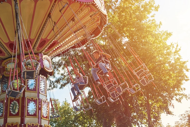 Children on the chain carousel in amusement park