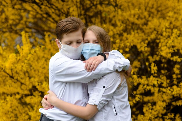 Foto bambini in un parco cittadino con maschera medica durante il periodo di quarantena del coronavirus