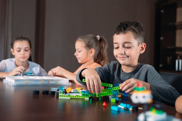 Photo children in the classroom collect figure from the designer.