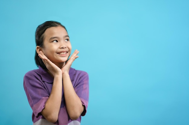 Children close up photo of cute and cheerful people, looking and smile on blue pastel background