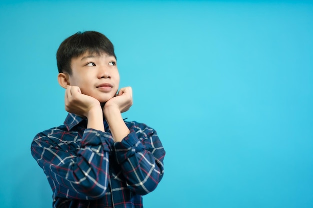 Children close up photo of cute and cheerful people, looking and smile on blue pastel background