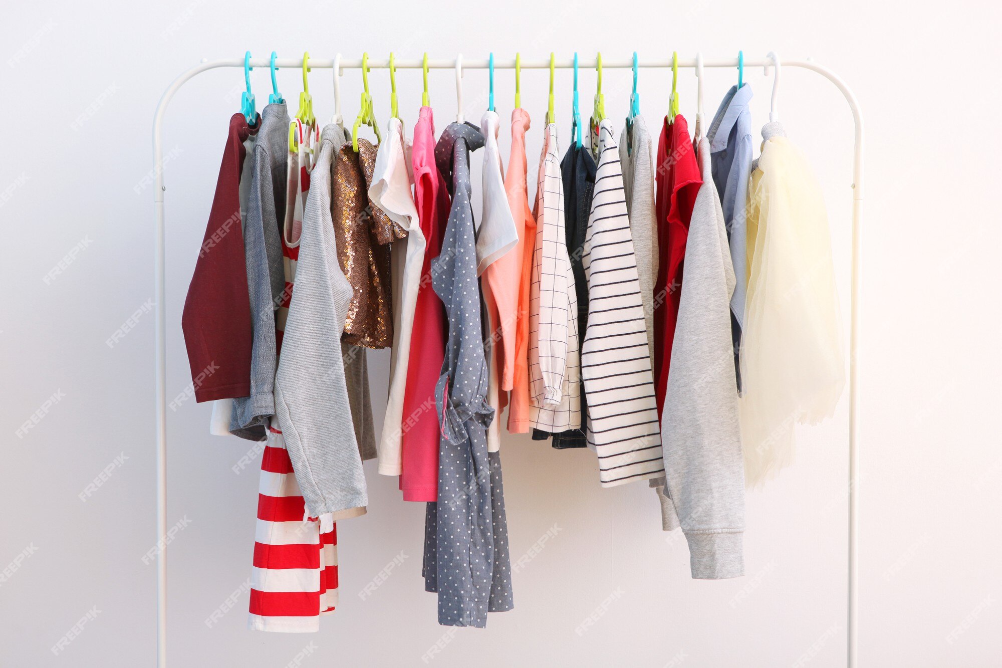 Premium Photo  Large selection of bright, colored children's clothes for a  girl hanging in a closet, on hangers.