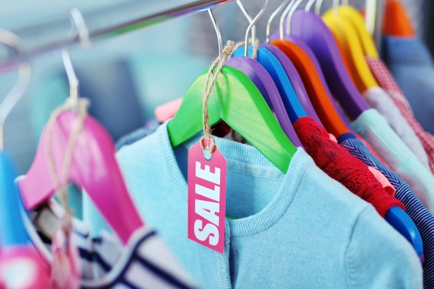 Children clothes hanging on hangers in the shop