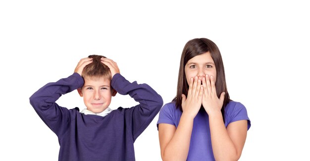 Children covering the ears and shocked by a loud sound isolated on a white