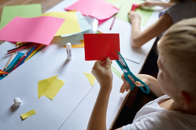 Foto i bambini tagliano la carta colorata, i bambini alla scuola d'arte