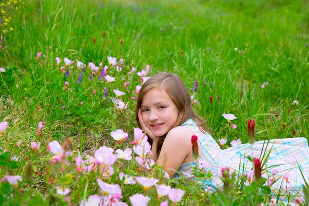 ケシの花と春の牧草地に子供かわいい女の子