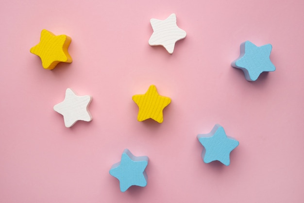 Children developmental toy for the development of motor skills a crescent wooden stars balancer on a pink background