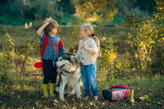 Children and dog exploring nature walk with kids and pet kids spending time together with a dog in f...