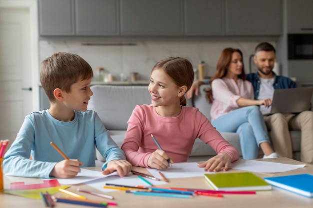 Children doing homework together parents on background