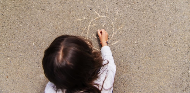 I bambini disegnano sul marciapiede con il gesso messa a fuoco selettiva