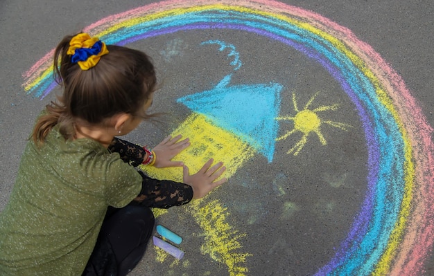 Children draw the Ukrainian flag house on the pavement Selective focus