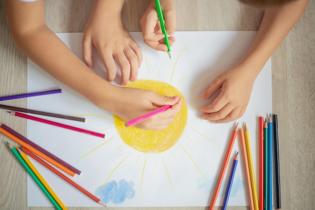 children drawing with colored pencils