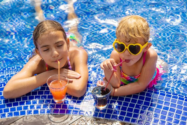 Children drink a cocktail in the pool Selective focus