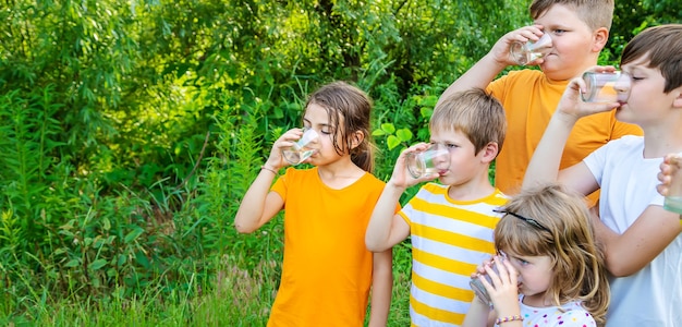 children drink water outside together.