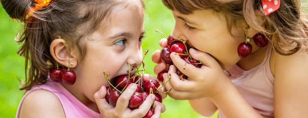 Children eat cherries in the summer. 