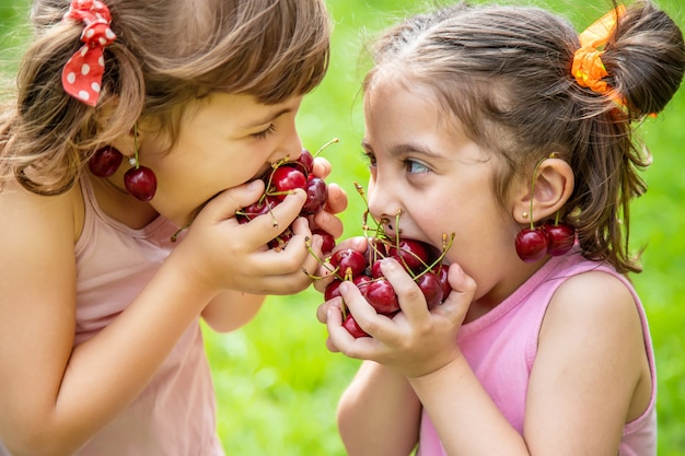 Children eat cherries in the summer