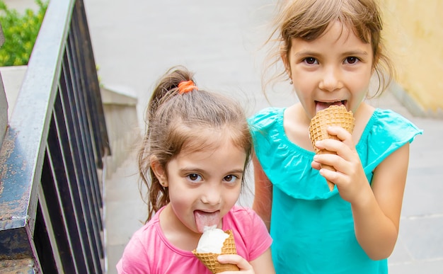 Children eat ice cream in the park. 