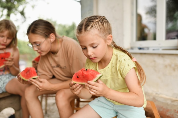 子供たちは村でスイカを食べます