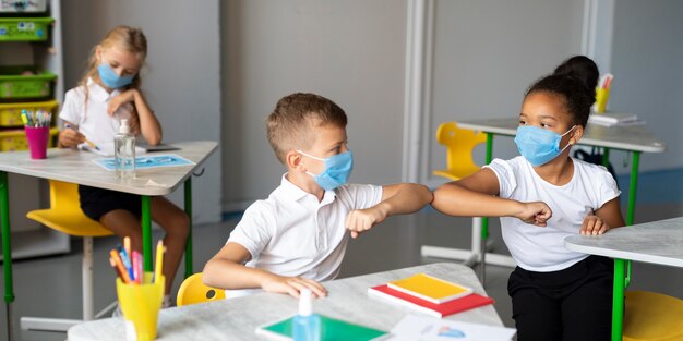 Children elbow bumping in class