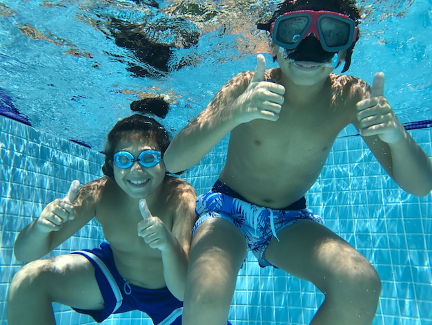 Children enjoying in pool underwater