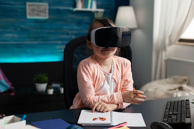 Children experiencing virtual reality using headset while sitting at desk table