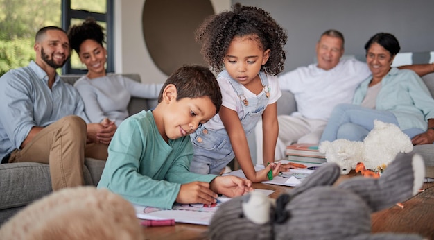 Famiglia dei bambini e apprendimento mentre disegnano arte per divertimento creativo con fratello e sorella nel salotto di casa con legami multigenerazionali ragazzi e ragazze che giocano con la supervisione di uomini e donne