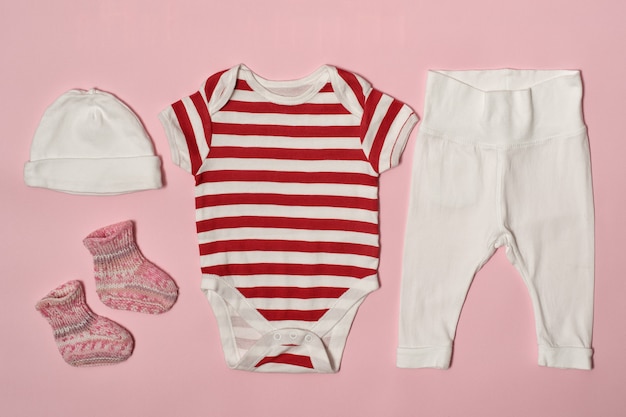 Children fashion  on a pink . Cap, bodysuit, pants and socks.