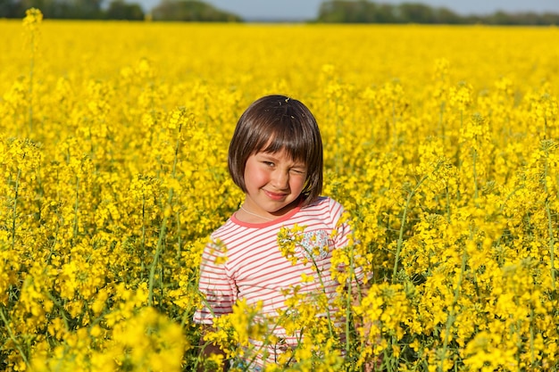 Children in the field with the flowering yellow flowers of rape