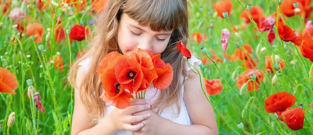Children girl in a field with poppies. 
