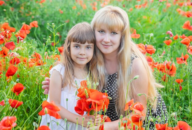 Children girl in a field with poppies.