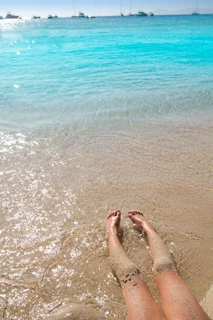 Children girl legs in beach sand shore