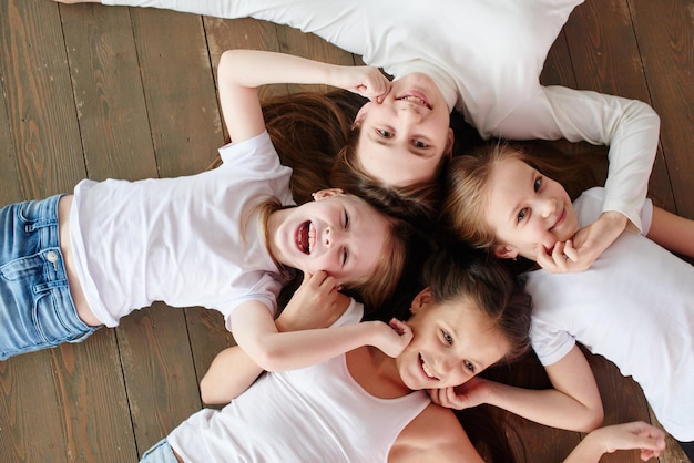 The children go in a circle. Four girls on the wooden floor, top view.